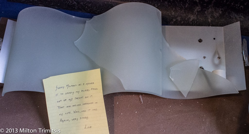 Broken light fixture with note in apology