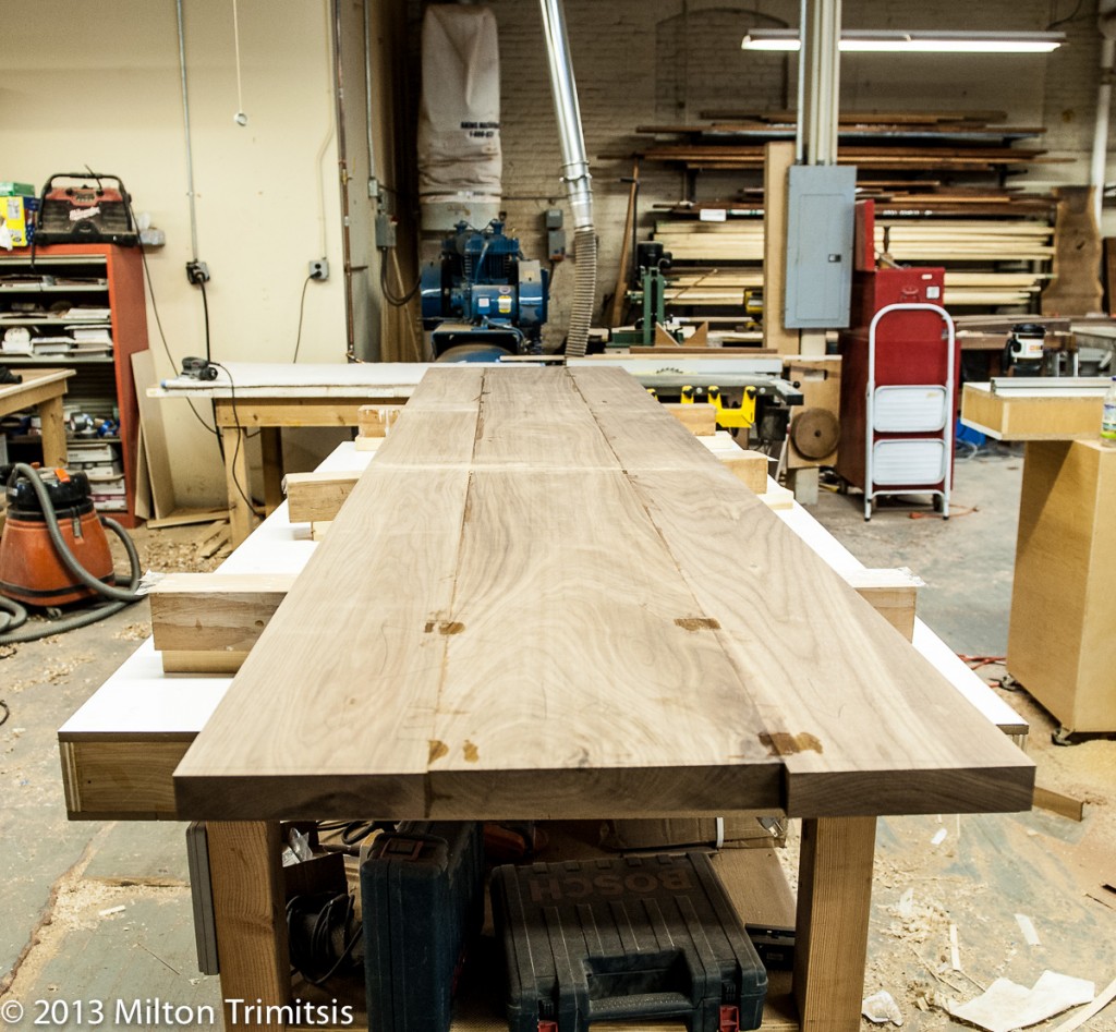 walnut boards in a woodshop being glued into a tabletop